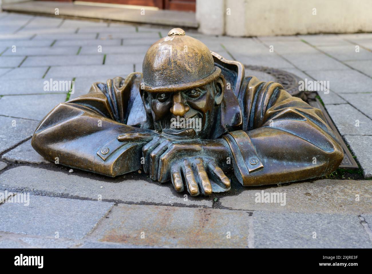 Bratislava, Slowakei – 25. Mai 2024: Cumil man at Work Bronzeskulptur mit Blick auf eine Gully-Hülle, die 1997 von Viktor Hulik hergestellt wurde Stockfoto