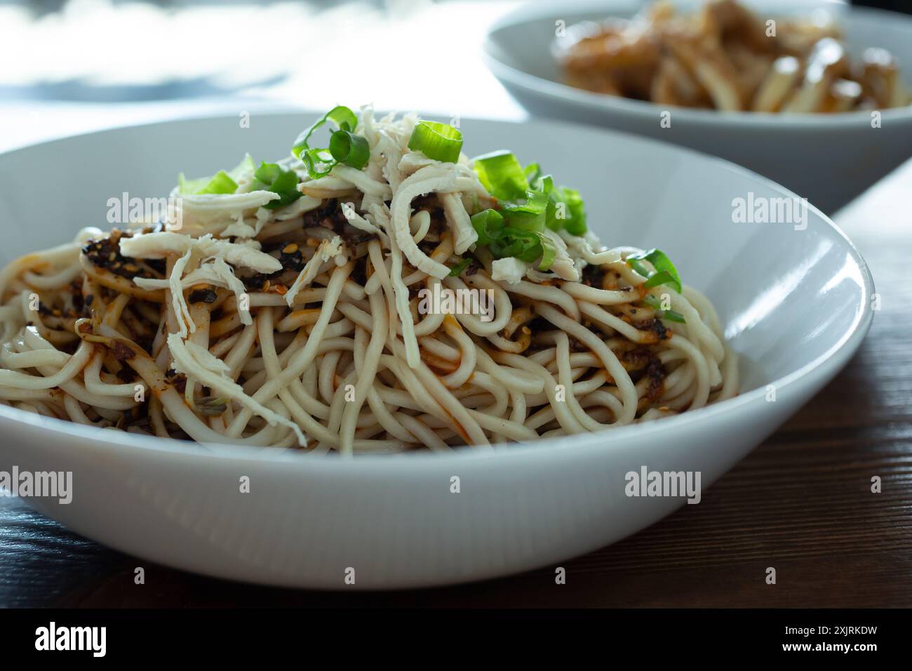 Ein Blick auf eine Schüssel Dan Dan-Dan-Nudeln mit gehacktem Huhn. Stockfoto