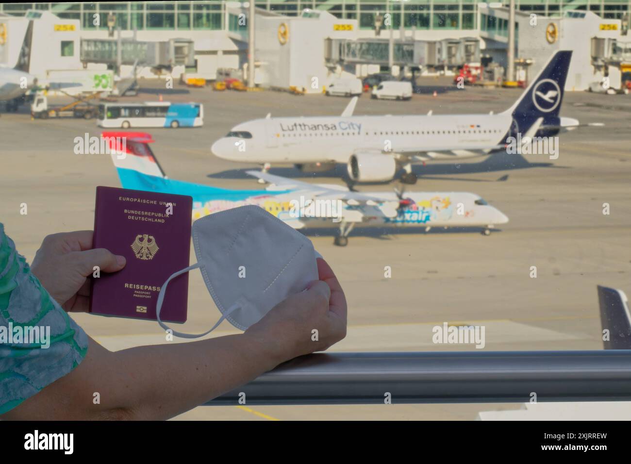 Die Corona-Fälle steigen an. Mit Reisepass und FFP2- Atemschutzmaske am Flughafen München. München Bayern Deutschland *** Corona-Fälle auf dem Vormarsch mit Pass und FFP2-Atemschutzmaske am Flughafen München Bayern Deutschland Copyright: XRolfxPossx Stockfoto