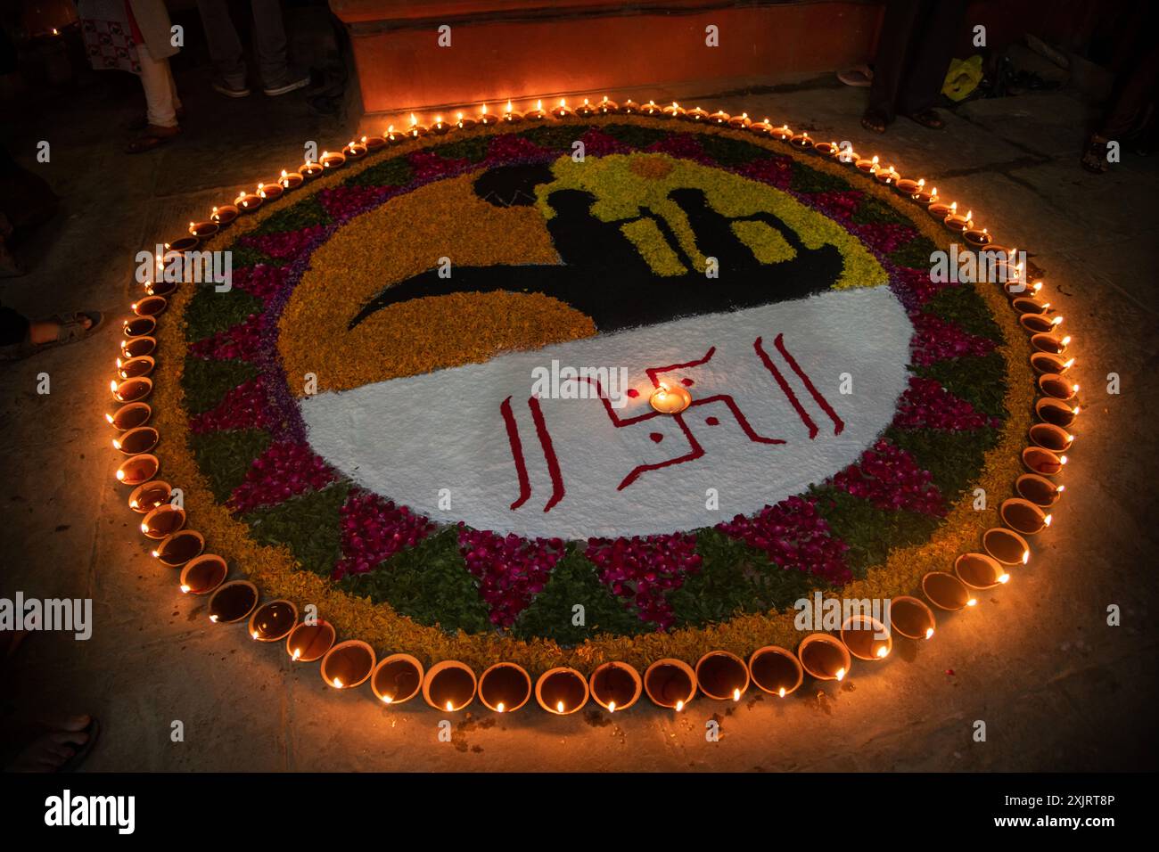 Lebendige Rangoli-Designs erwachen unter dem warmen Glanz der Lampen (Diyas) zum Leben und symbolisieren den festlichen Geist und den Triumph des Lichts über die Dunkelheit. Stockfoto