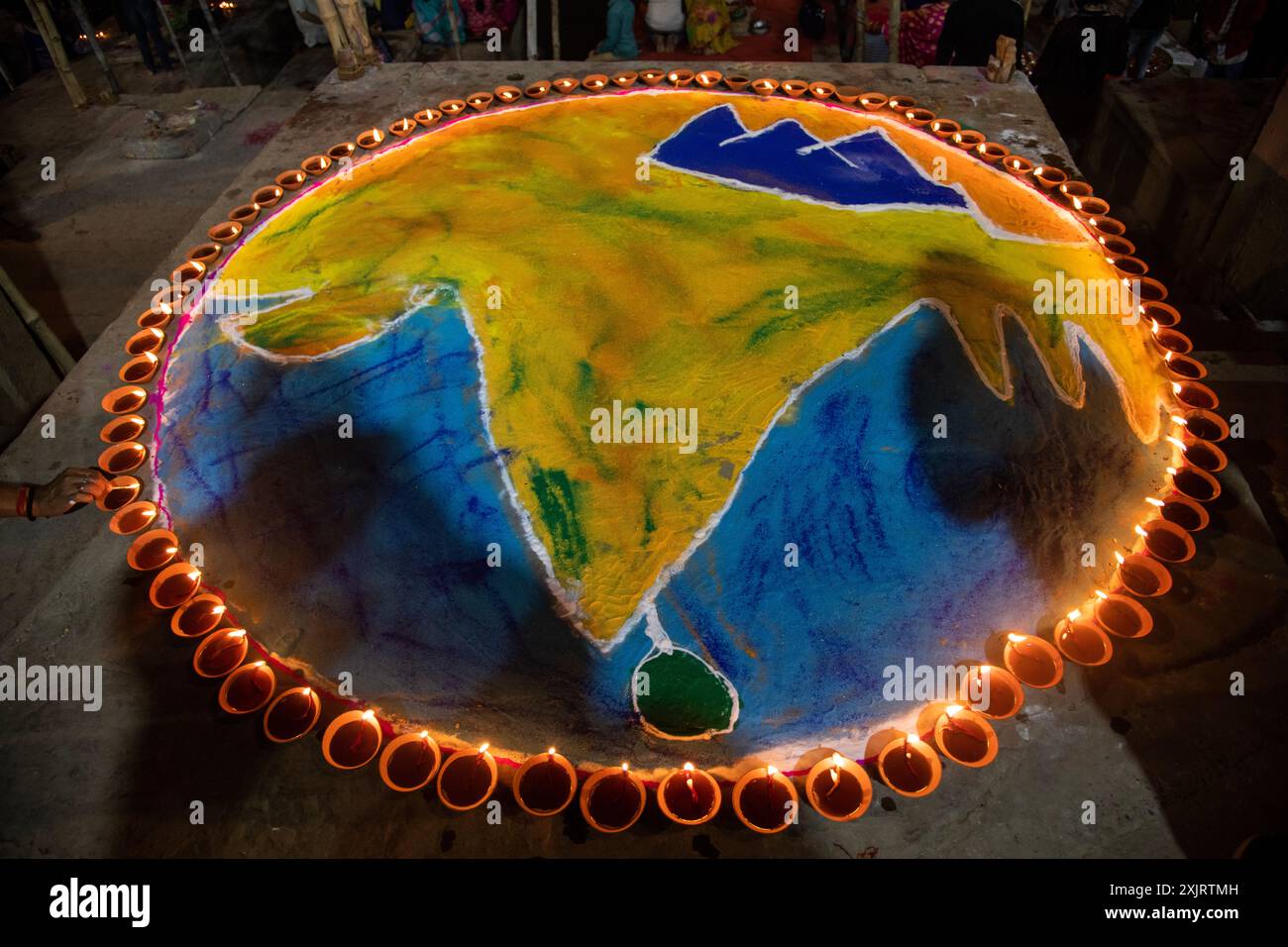 Lebendige Rangoli-Designs erwachen unter dem warmen Glanz der Lampen (Diyas) zum Leben und symbolisieren den festlichen Geist und den Triumph des Lichts über die Dunkelheit. Stockfoto