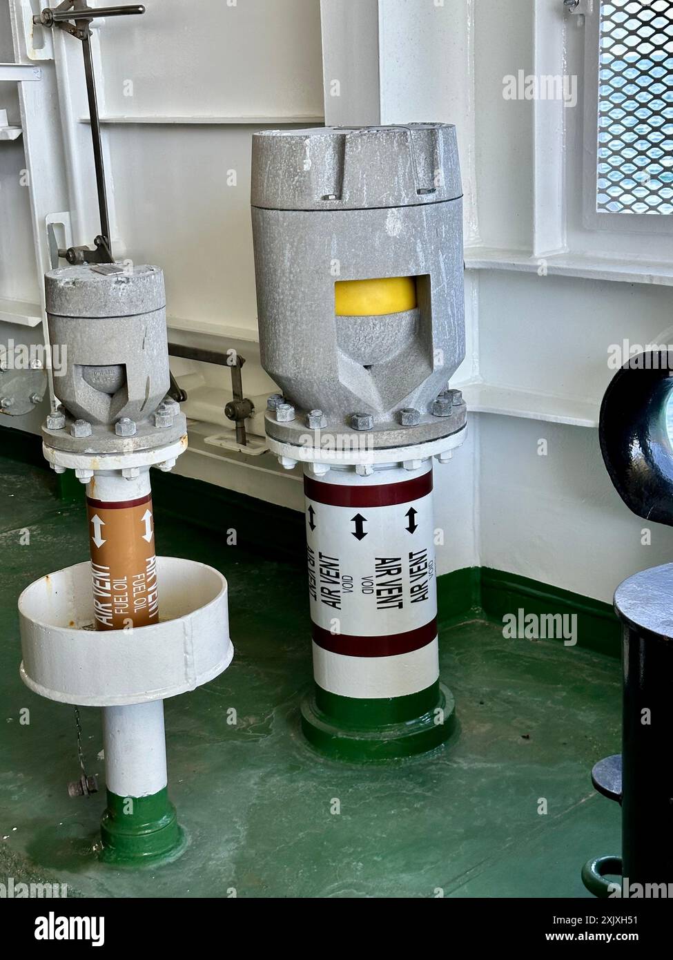 Armaturen und Anlagen für Industriemaschinen befinden sich auf einem belebten grünen Stockwerk. Schiffsausrüstung auf der Fähre Stockfoto