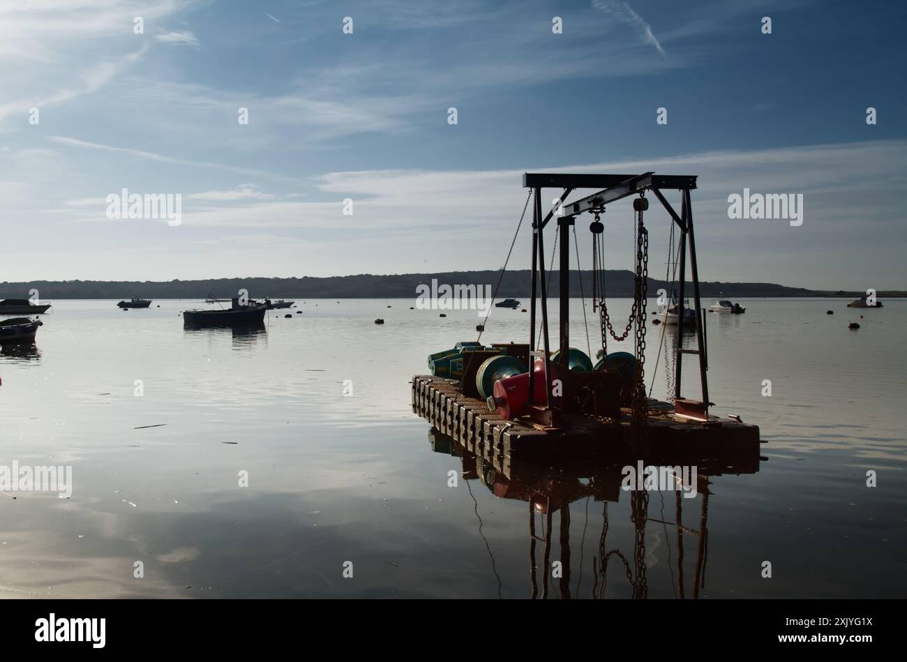 Schwimmender tragbarer Kran, Derrick mit Riemenscheiben und Ketten, mit denen Bojen und Kanalmarkierungen fallen gelassen werden, schwimmend am Christchurch Harbour an Einem ruhigen Tag, Großbritannien Stockfoto