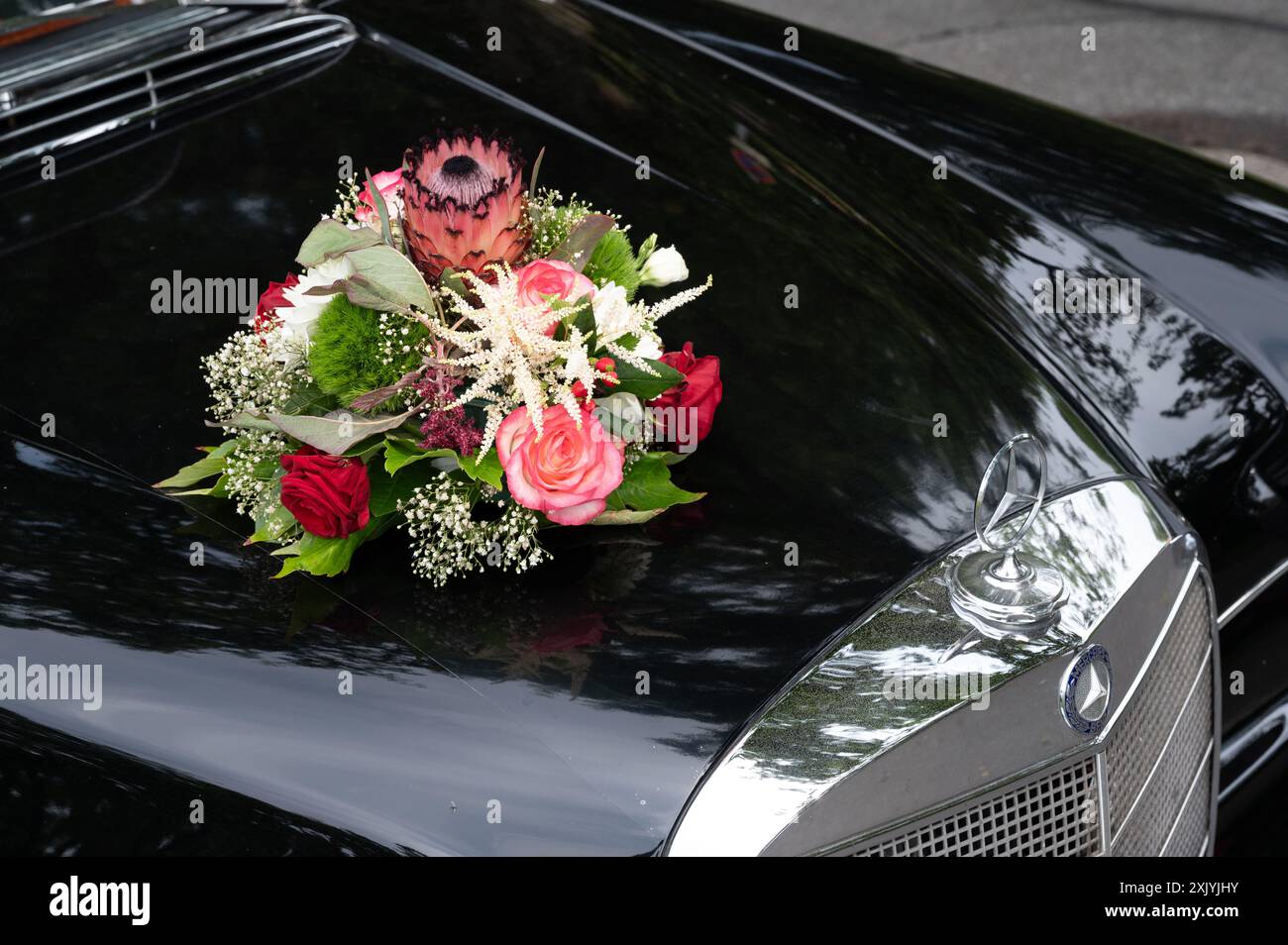 Hochzeitsauto mit Blumenschmuck, schwarzer Mercedes-Benz Oldtimer Stockfoto