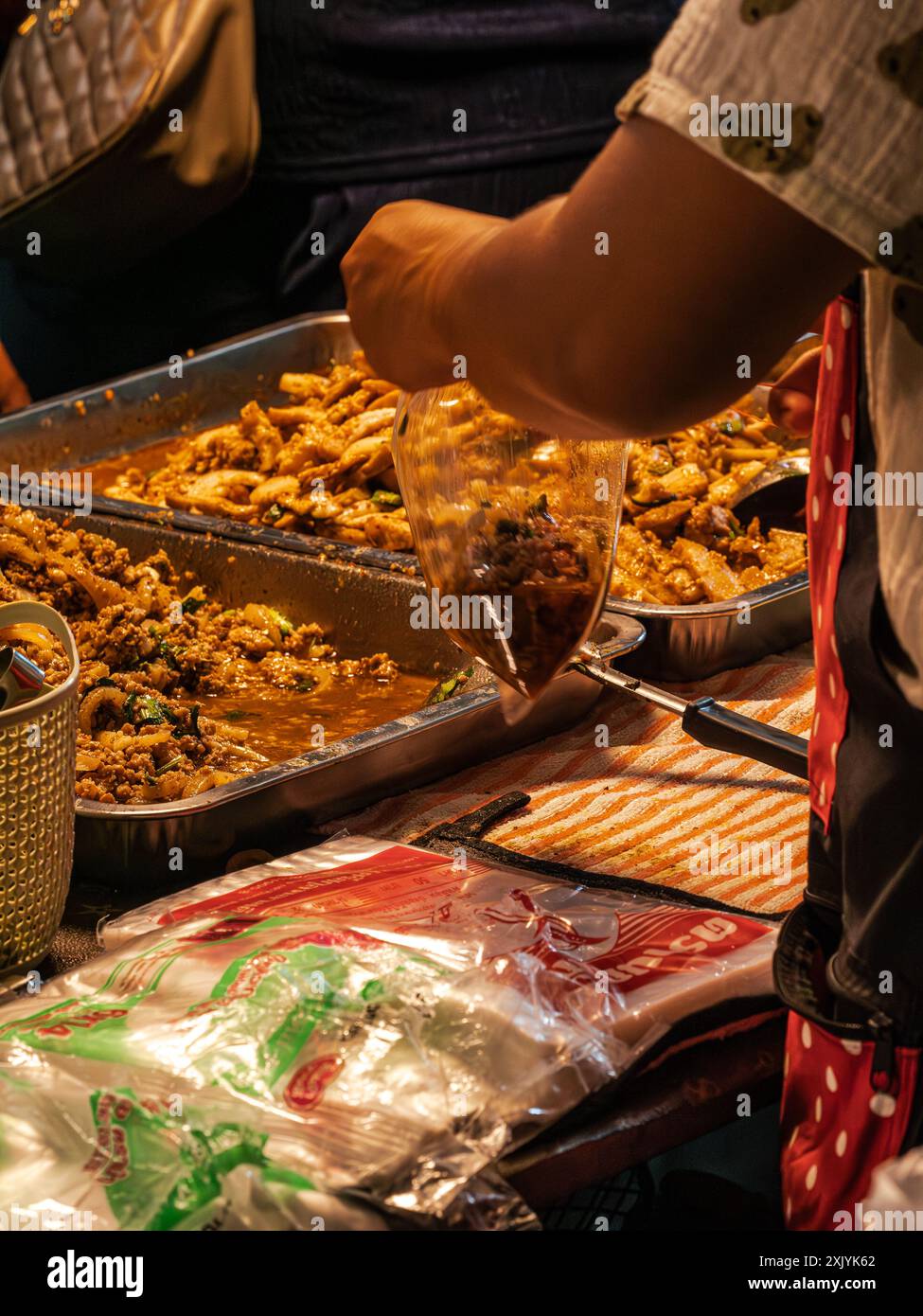 Street Food Vendor serviert Essen in einer Plastiktüte Stockfoto
