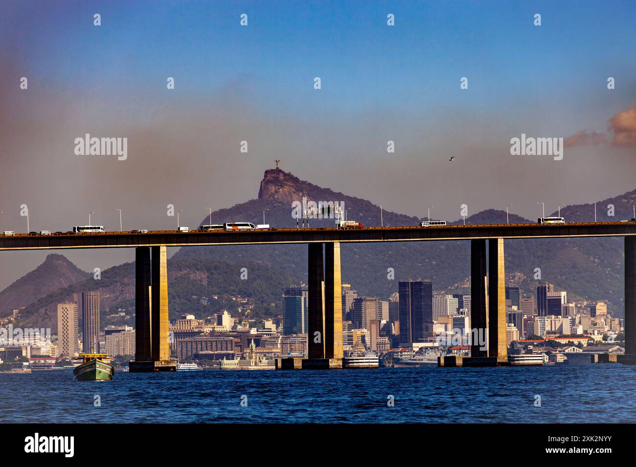 Rio-Niteroi-Brücke an der Guanabara-Bucht - dichte Luftverschmutzung über der Innenstadt von Rio de Janeiro - Christusstatue und Corcovado-Berg im Hintergrund. Rio de Janeiro, Brasilien. Stockfoto