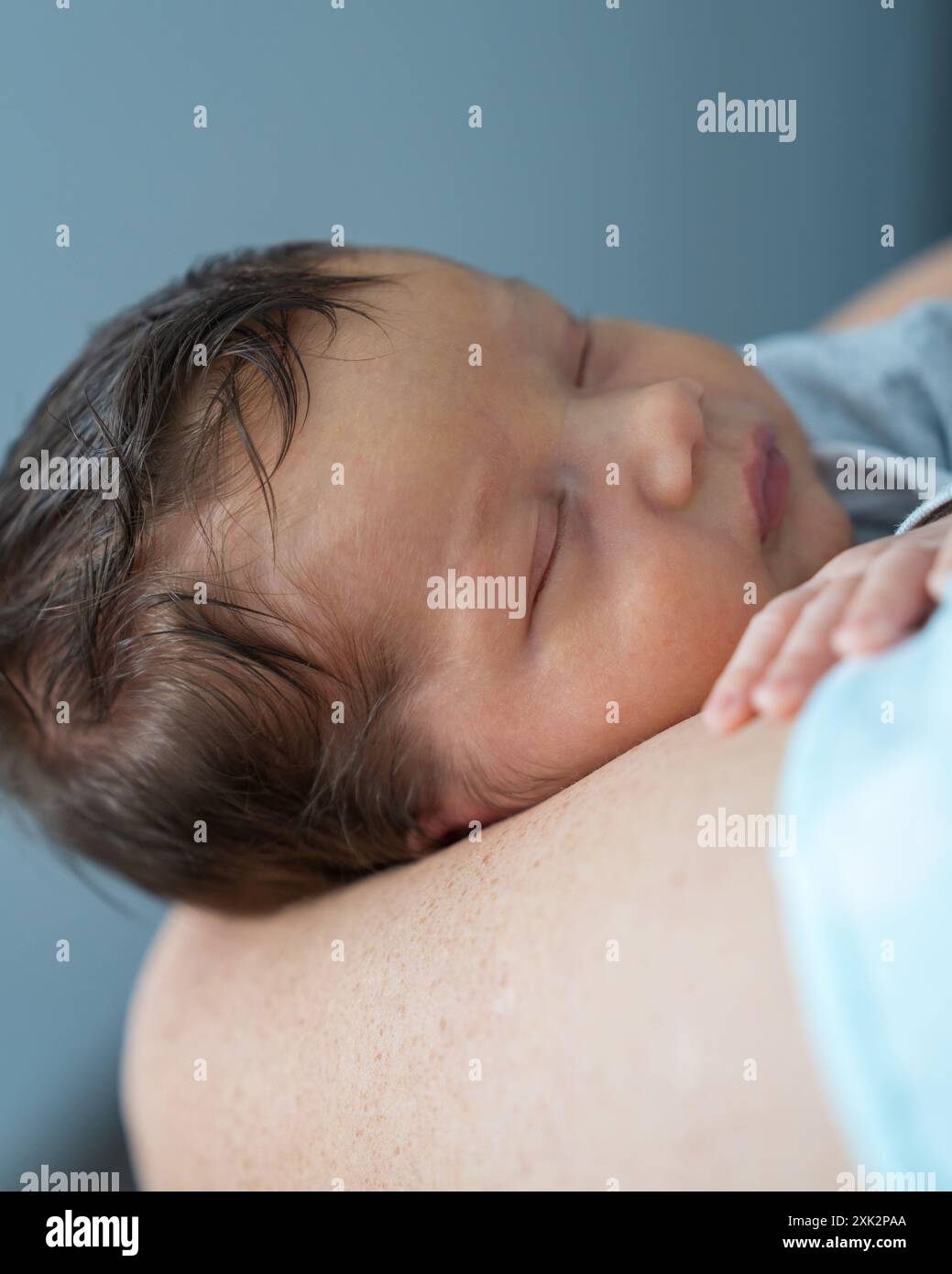 Der Kopf des Babys in den Händen der Mutter. Mom hält einen neugeborenen Jungen, das Baby schläft süß. Säuglingsgesundheit und -Entwicklung. Die Geburt eines Kindes und die Liebe von p Stockfoto