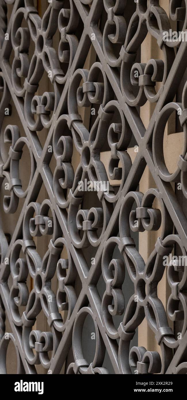 Geschmiedetes Metallschutzgitter an einem alten Fenster. Metallmuster. Bauen für Sicherheit. Geschmiedetes Metallschutzgitter an einem alten Fenster. Metallmuster Stockfoto