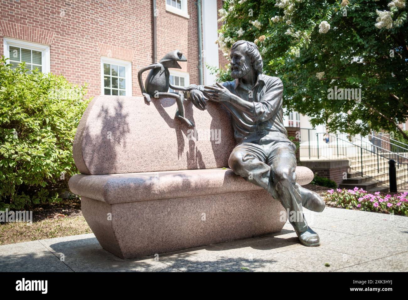 COLLEGE PARK, Maryland, USA – das Jim Henson Memorial an der University of Maryland zeigt eine Bronzestatue des berühmten Puppenspielers mit seiner berühmten Schöpfung Kermit dem Frosch. Henson, ein Alumnus der Universität von Maryland, ist in entspannter Pose auf einer Bank zu sehen. Die Gedenkstätte außerhalb der Adele H. Stamp Student Union würdigt Hensons kreatives Erbe und seine Verbindung zur Universität. Stockfoto