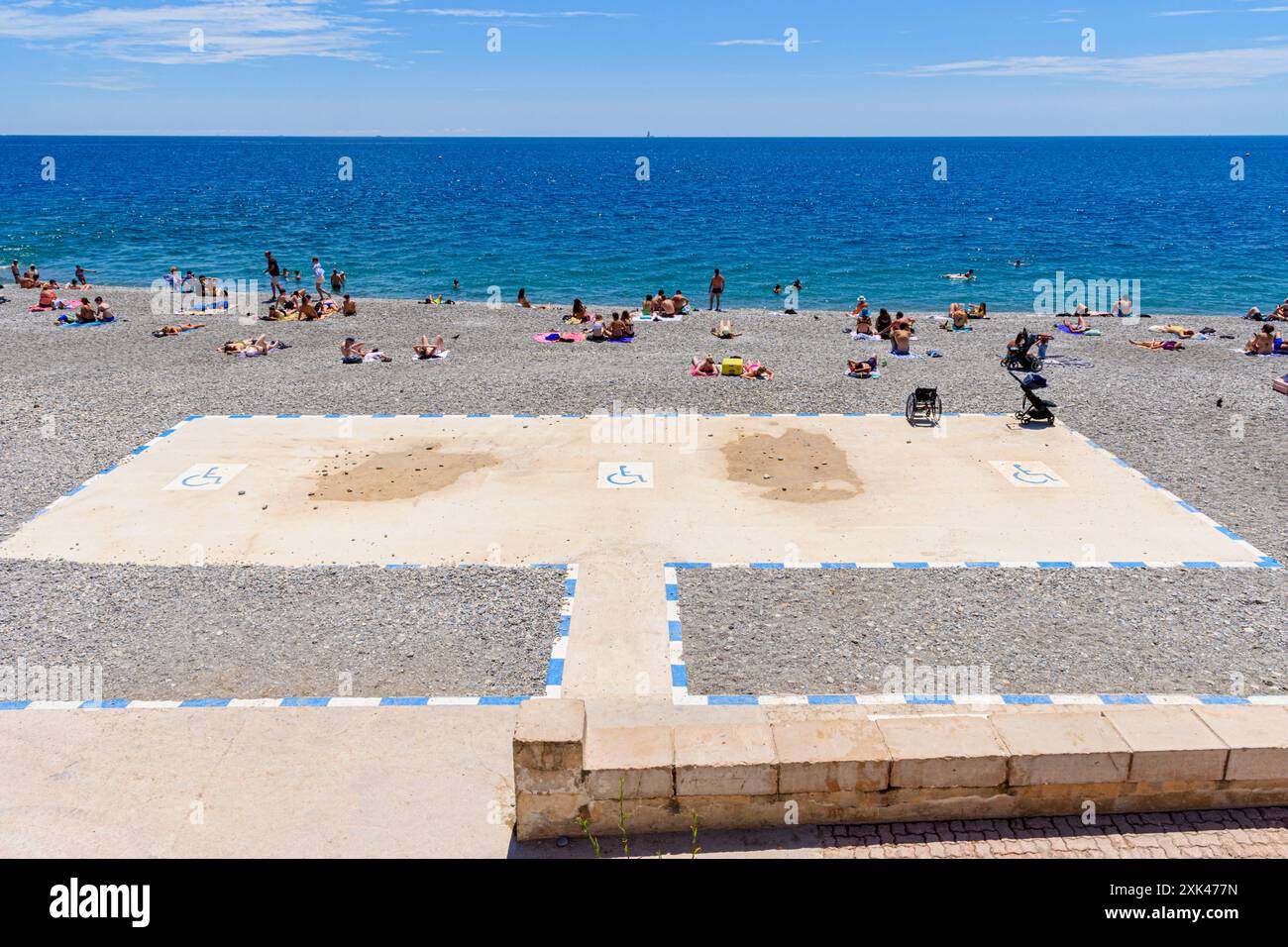 Die Zufahrtsrampe und ein flacher Weg führen zu einer rollstuhlgerechten Platte am Strand in Nizza, Provence-Alpes-Côte d'Azur, Alpes-Maritimes, Frankreich Stockfoto