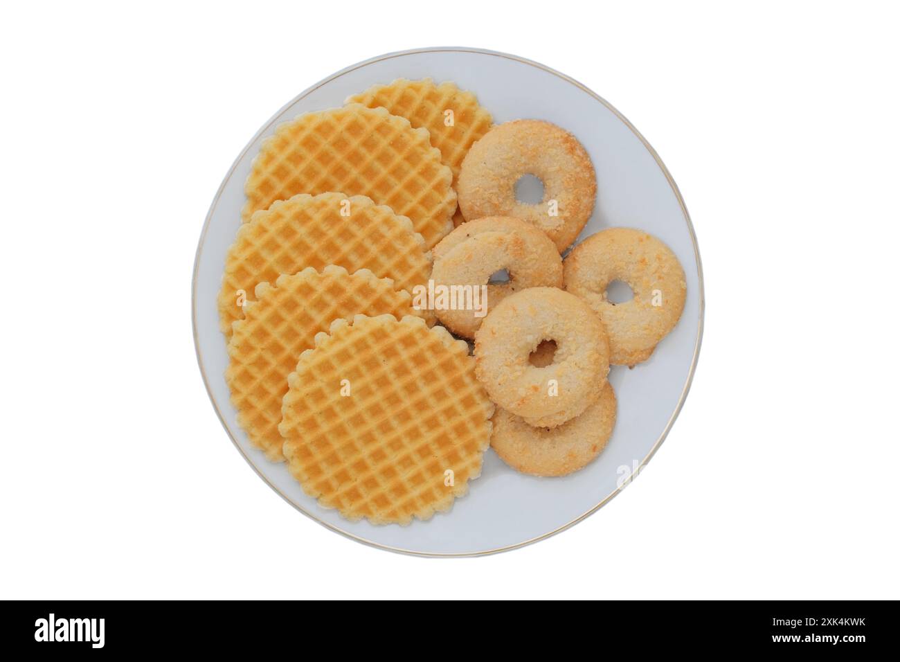 Verschiedene Kuchen und Waffeln in Keramikplatte isoliert auf weißem Hintergrund. Gelber romantischer Keks. Draufsicht. Stockfoto