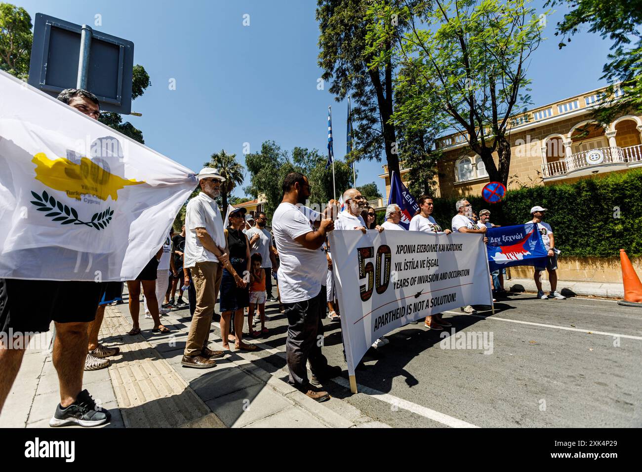 Zypern : entlang der Grünen Linie versammelte sich am Kontrollpunkt des Ledra-Palastes Eine Gruppe griechisch-zypriotischer und türkischer Zyprioten, um gegen die Situation in Zypern zu protestieren und am 20. Juli 2024 die Einigung und den Frieden zwischen allen Gemeinschaften, Nikosia, Zypern, zu fordern. Die Grüne Linie oder Pufferzone trennt die Insel seit 1963 als erste Maßnahme zur Verhinderung von Feindseligkeiten zwischen griechisch-zypriotischen und türkisch-zypriotischen Volksgruppen. aber seit der türkischen Invasion im Jahr 1974 fungiert sie als de-facto-Grenze zwischen der Republik Zypern und der selbsterklärten türkischen Republik Nordzypern, die nur die Türkei als eine l anerkennt Stockfoto