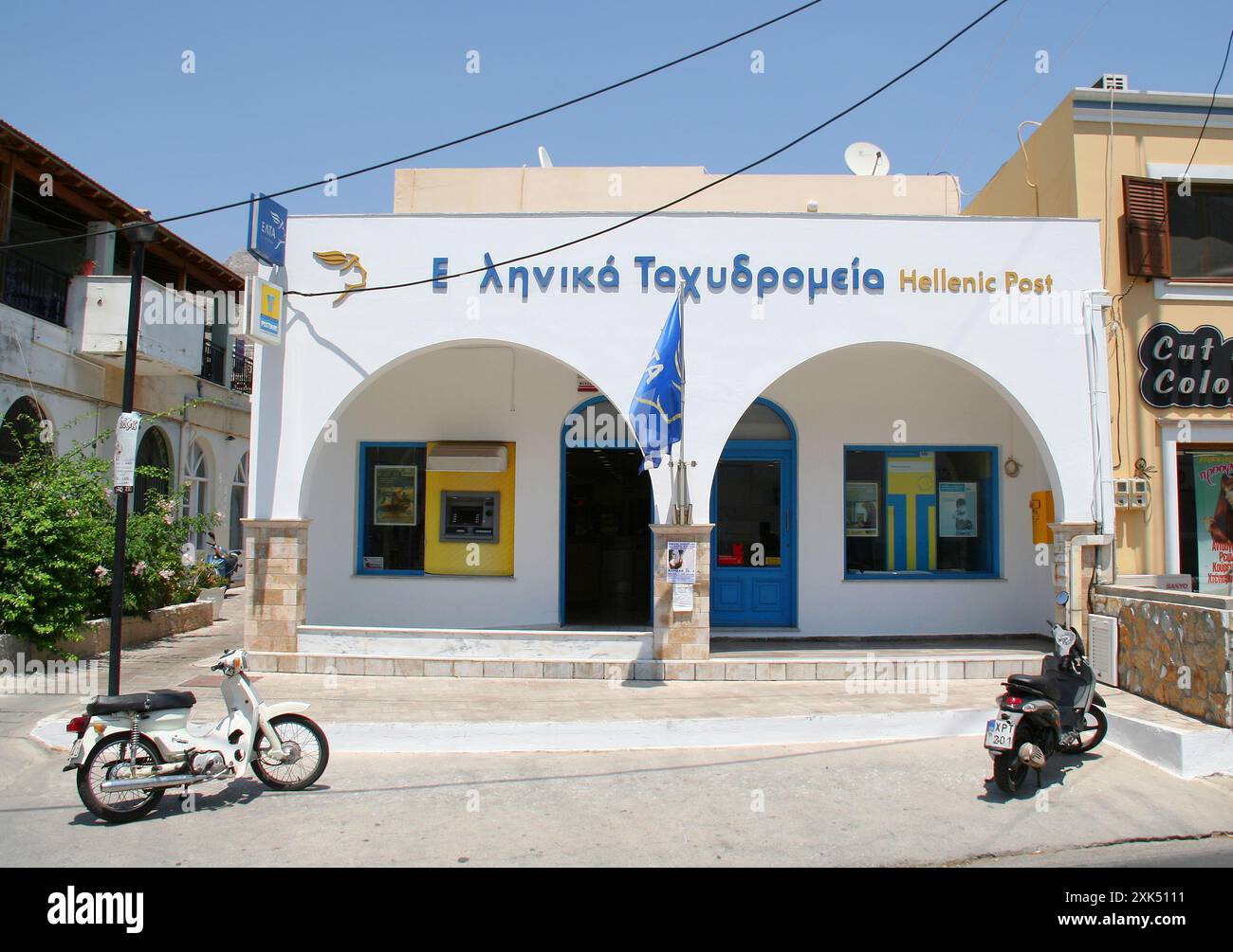 KALYMNOS, GRIECHENLAND-16. JULI 2013: Motorroller parken vor dem Gebäude der griechischen Post Stockfoto