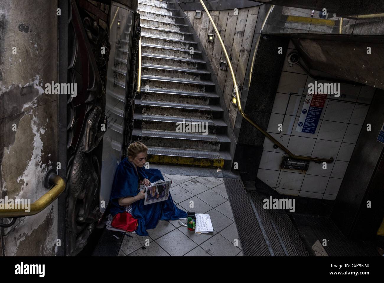 Obdachlose Frau sitzt unten am Treppeneingang zur Bank London Underground Station, England, Großbritannien Stockfoto