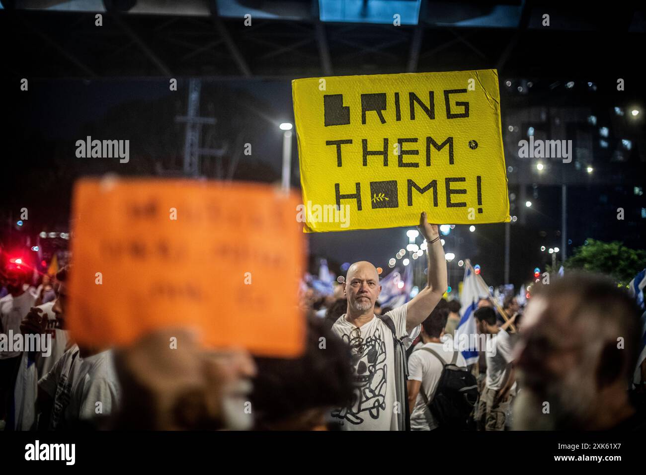 Tel Aviv, Israel. Juli 2024. Ein Demonstrant hält während einer Protestkundgebung in Tel Aviv am Samstag, den 20. Juli 2024 ein Schild hoch. Regierungsfeindliche Demonstranten versammelten sich am Samstagabend in den Städten Israels und forderten Premierminister Benjamin Netanjahu auf, am nächsten Tag nicht zu einem geplanten Besuch in Washington zu reisen, bis er zuerst ein Abkommen mit der Hamas unterzeichnet hat, um die Rückkehr der Geisel aus Gaza zu erleichtern. Es bestehen noch Meinungsverschiedenheiten zwischen Netanjahu und Israels Verhandlungsteam über Geiselabkommen vor dem geplanten Besuch des Premierministers in Washington und seiner Rede vor dem Kongress. Foto von Eyal Warshavsky. Kredit: Eyal Stockfoto