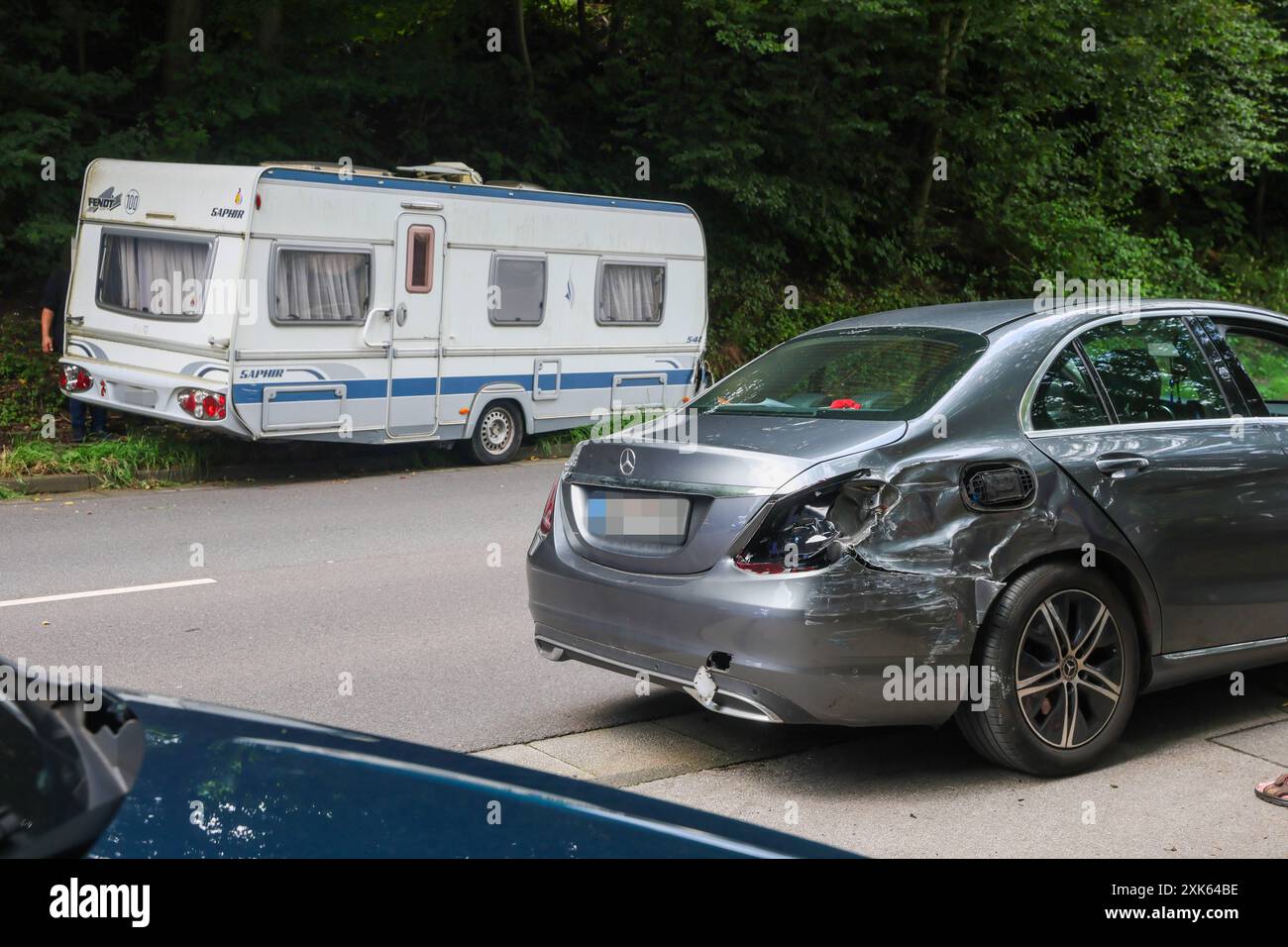 Kurioser Unfall am Sonntagnachmittag in Solingen: Wohnwagen rollt führerlos in Gegenverkehr Kurioser Unfall am Sonntagnachmittag in Solingen: Wohnwagen rollt führerlos in Gegenverkehr ein führerloser Wohnwagen rollte Autofahrern auf der Kohlfurther Straße am Sonntag 21.07.2024 entgegen. Eine Autofahrerin beschrieb die Situation beängstigend: Wir konnten gerade so eben auf diesen Feldweg ausweichen, als der Wohnwagen uns auf beiden Spuren entgegen kam. Mindestens ein entgegenkommender PKW Mercedes wurde durch den Wohnwagen erheblich beschädigt, alle anderen Fahrzeuge konnten, wie durch ein Wund Stockfoto