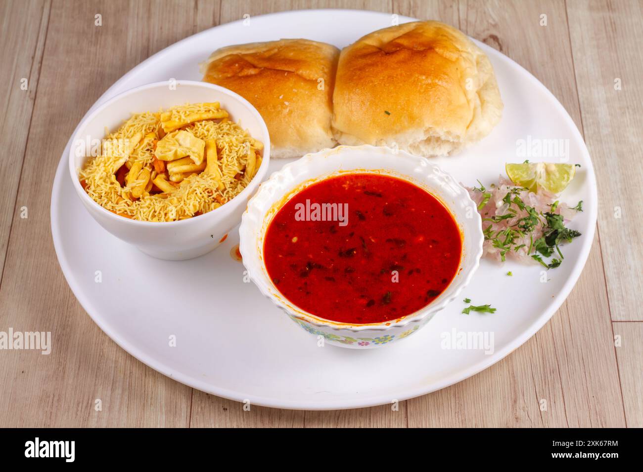 Picy Misal Pav oder Ual Pav ist ein traditioneller Snack oder Chaat Food aus Maharashtra, Indien. Serviert mit gehackten Zwiebeln, Zitronenscheiben und farsan. Selektiv Stockfoto