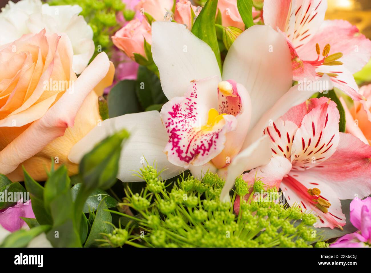 Ein Blick aus der Nähe eines Blumenstraußes mit einer weißen Bootsorchidee, auch bekannt als Cymbidium. Stockfoto
