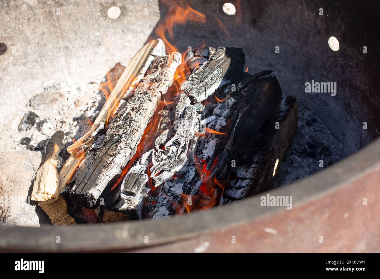 Ein Blick in ein Lagerfeuer. Flammen brennen durch Brennholz. Stockfoto
