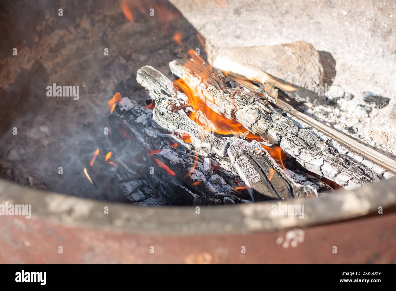Ein Blick in ein Lagerfeuer. Flammen brennen durch Brennholz. Stockfoto