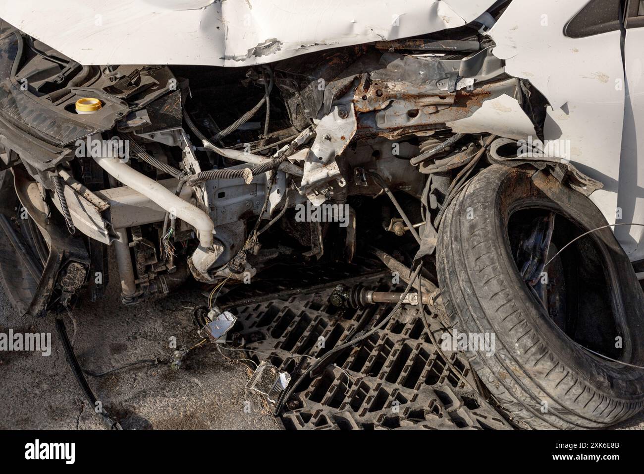 Detaillierte Ansicht des beschädigten Fahrzeugs nach einem Unfall, freigelegt von zerquetschten Motorteilen, verwickelten Wrackteilen. Ideal für den Einsatz in Materialien zur Verkehrssicherheit Stockfoto