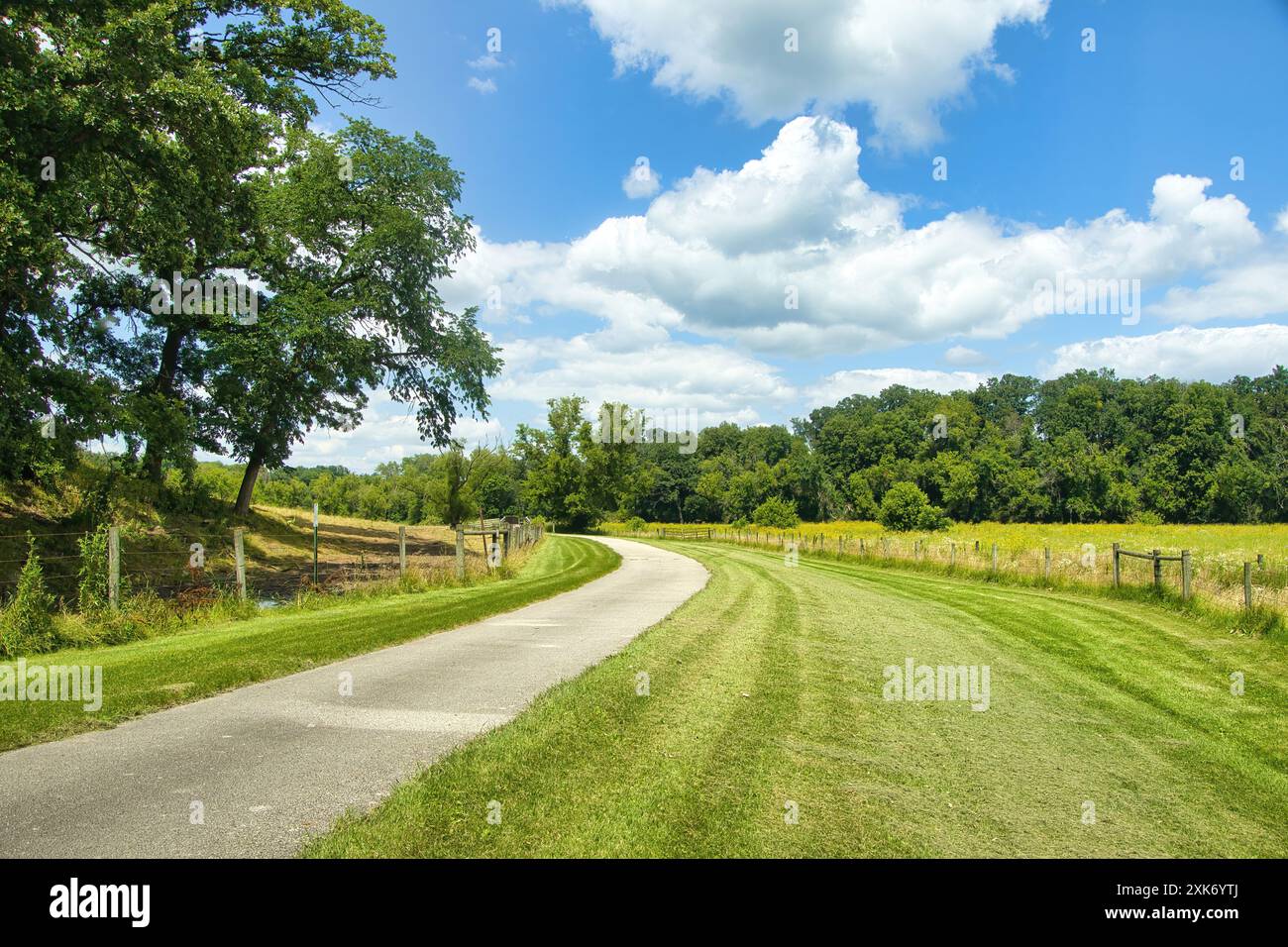 Sonnige Sommerlandschaft des Harmony-Preston Valley Recreational Trail, der durch üppig grüne Ackerflächen und Wälder im Süden von Minnesota führt. Stockfoto
