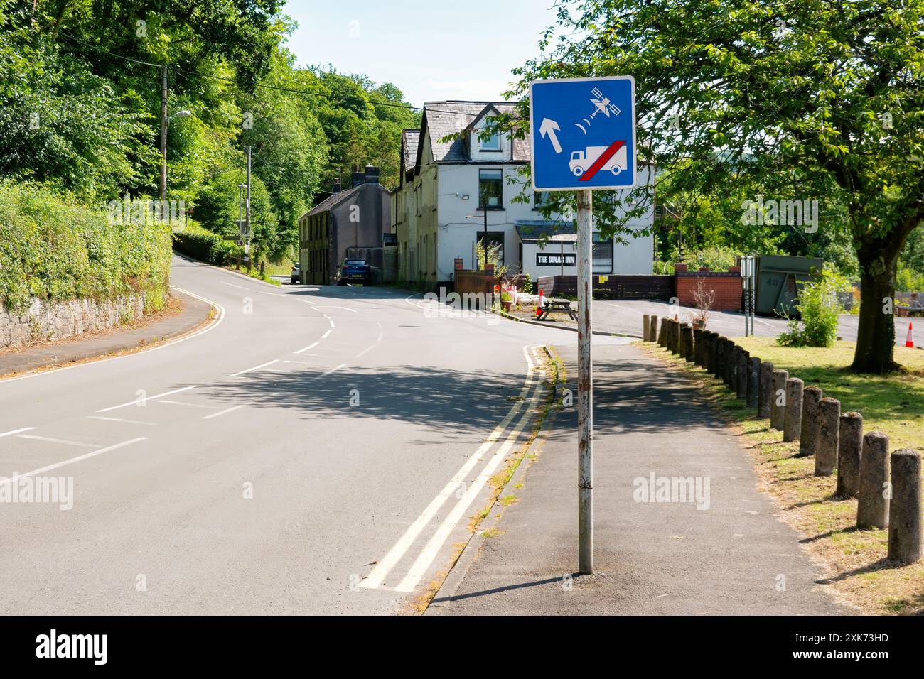 Wales, Großbritannien. Ein Verkehrsinformationsschild, das LKW und andere große Fahrzeuge anweist, die Ratschläge des Navigationssystems zu ignorieren, um die ungeeignete schmale Straße vor sich zu nehmen Stockfoto