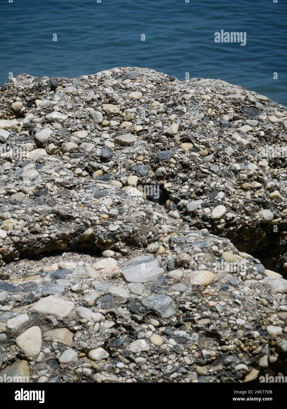 Nahaufnahme von Konglomerat-Sedimentgestein, die die Küstenklippen von Nerja, Andalusien, Spanien bilden Stockfoto