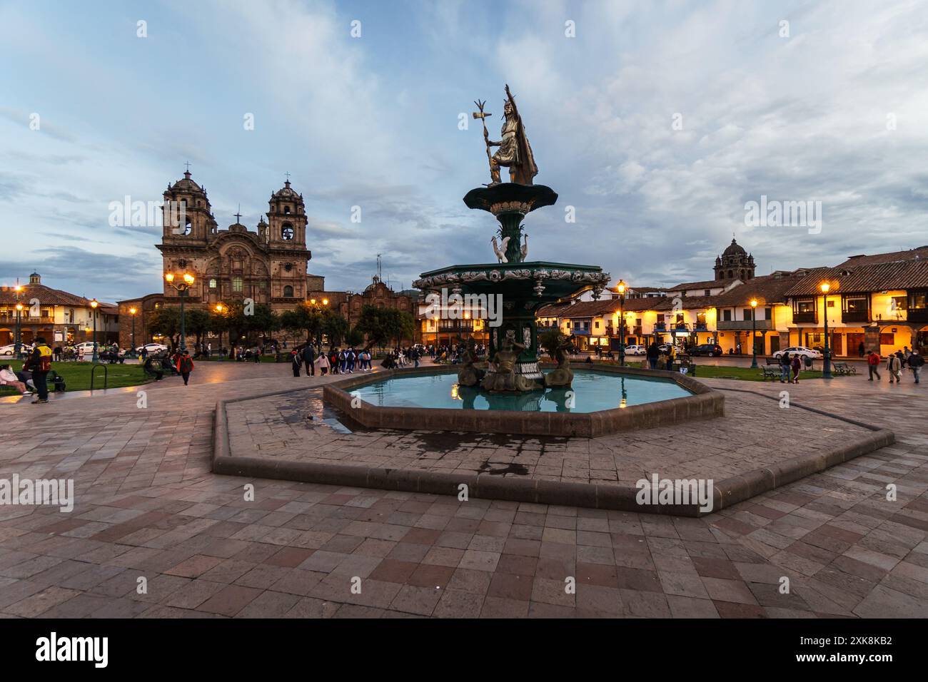 Cusco, Peru: Der Kaiser des INCO bestieg den Brunnen mitten auf der plaza de armas in der Kolonialzeit von Cusco in der Abenddämmerung mit der Kirche der Gesellschaft der Jes Stockfoto