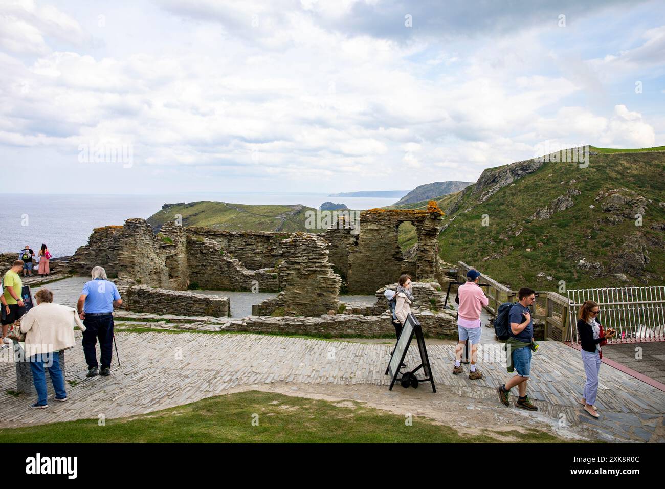 Tintagel Castle Ruinen, Touristen und Besucher sehen die Burgruinen aus dem 13. Jahrhundert auf Tintagel Island im Norden von Cornwall, England, Großbritannien Stockfoto