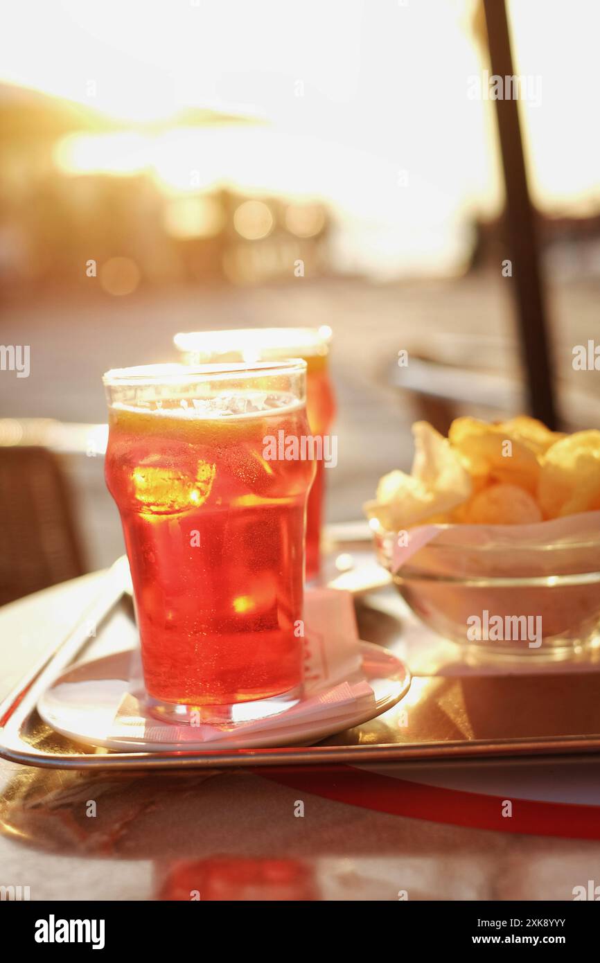 Genießen Sie einen Spritz und eine Schüssel mit kostenlosen Chips bei Sonnenuntergang an der Uferpromenade in Zattere Dorsoduro, Venedig, Italien Stockfoto