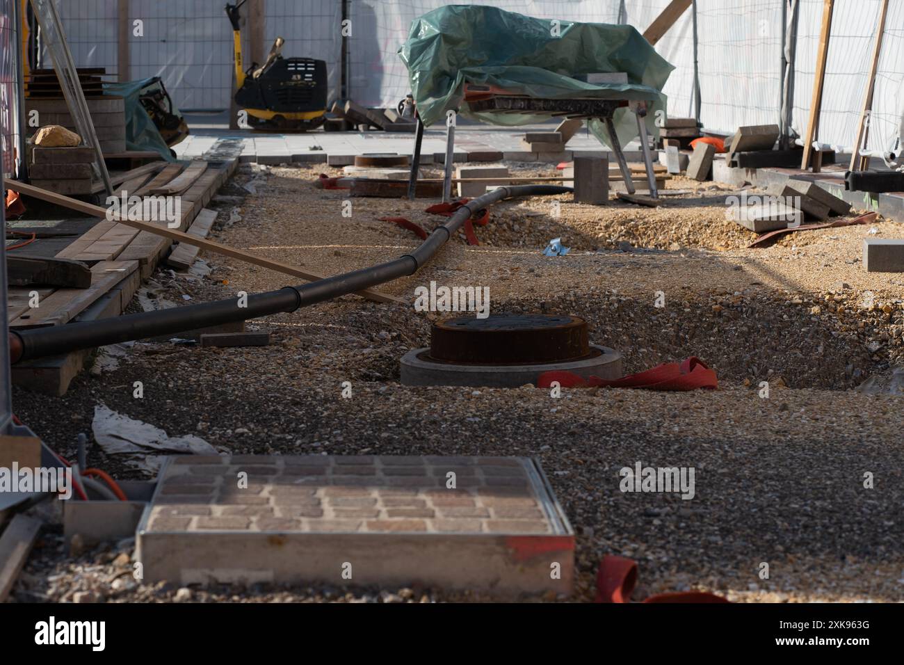 Baumaterialien und -Ausrüstung auf der Straßenreparaturstelle. Stockfoto
