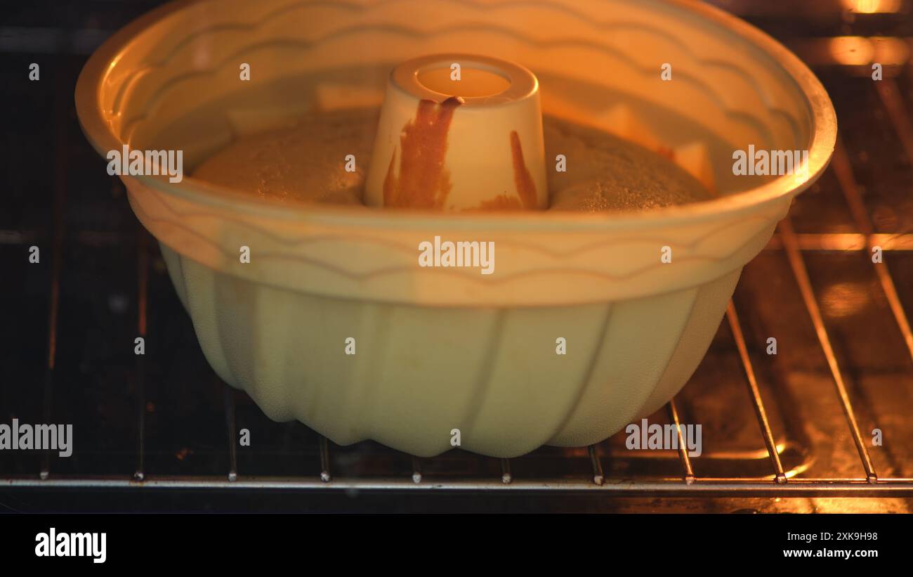 Bundt Kuchen im Ofen backen. Nahaufnahme. Hausbacken und Dessertzubereitungskonzept. Stockfoto