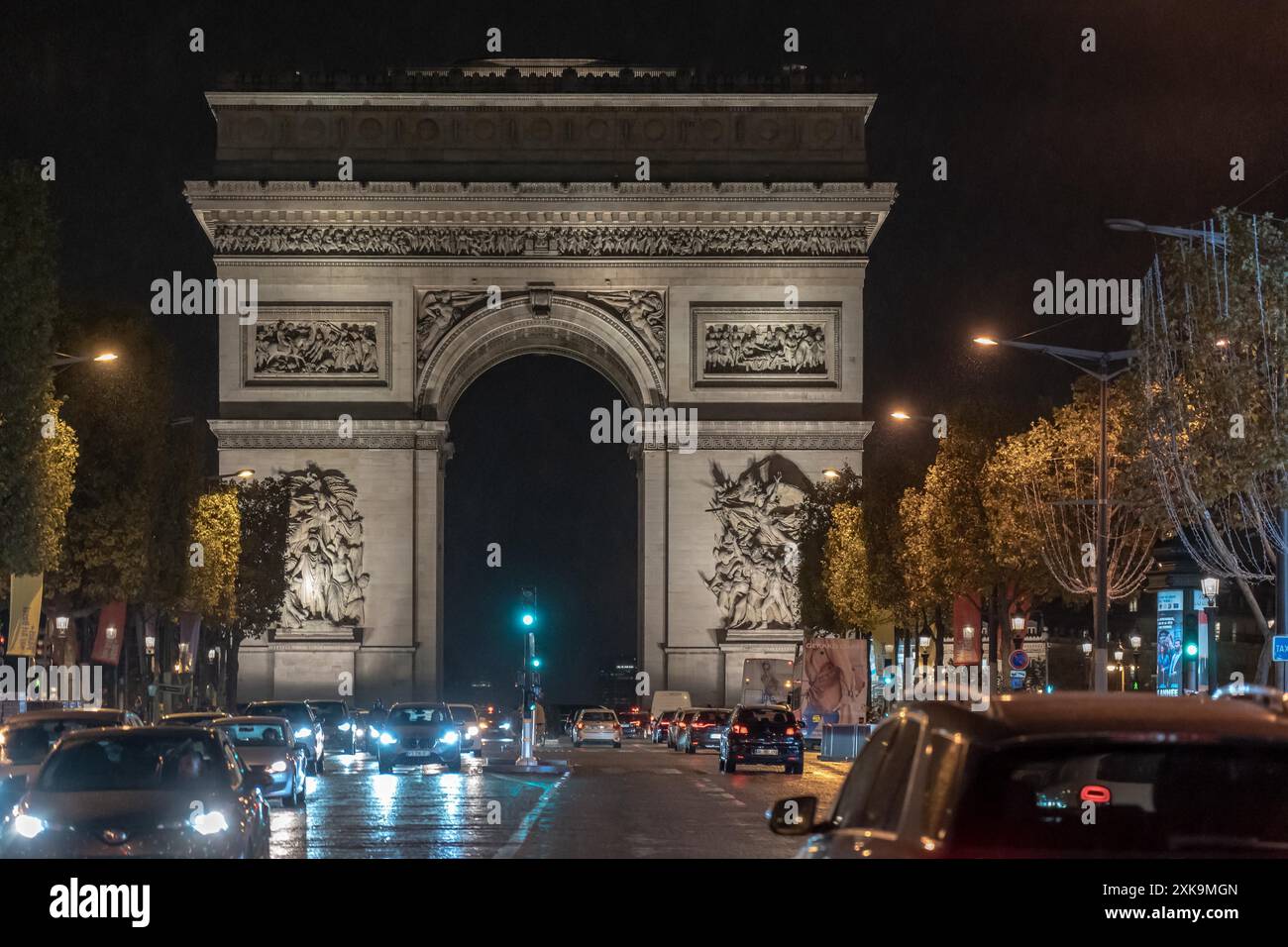 Paris, Frankreich - 19. Oktober 2023 : der Arc de Triomphe in Paris, Frankreich bei Nacht mit vorbeifahrenden Autos. Stockfoto