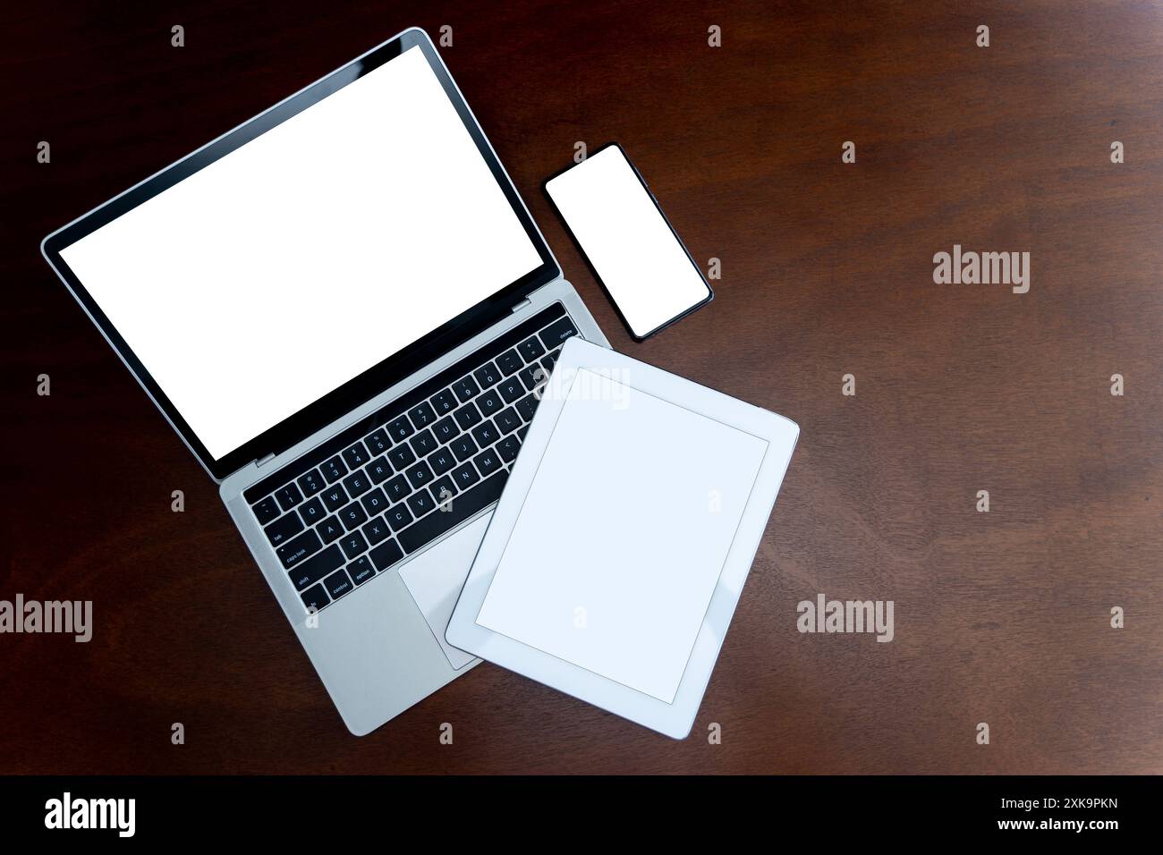 Laptops, Tablets und Smartphones mit leeren Bildschirmen auf dem Tisch, Geräte werden heutzutage in der Kommunikationstechnologie stark eingesetzt. Flache Draufsicht mit Kopie Stockfoto