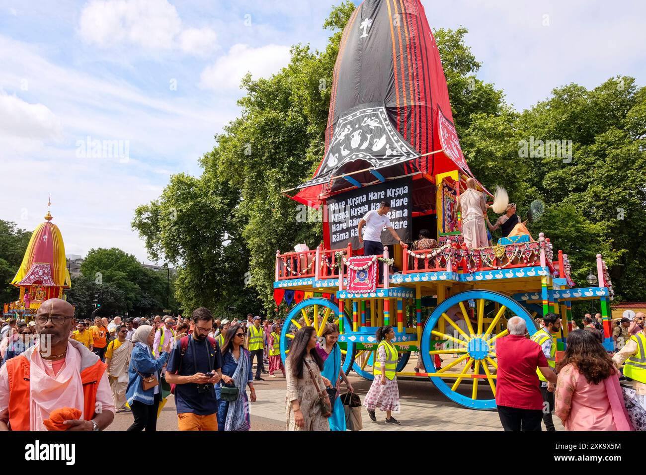 Juli 2024, London UK. Anhänger der Hare Krishna-Religion nehmen an der London Rathayatra Parade Teil, während drei große, farbenfrohe Wagen von Hand durch die Straßen Londons gezogen werden. Stockfoto