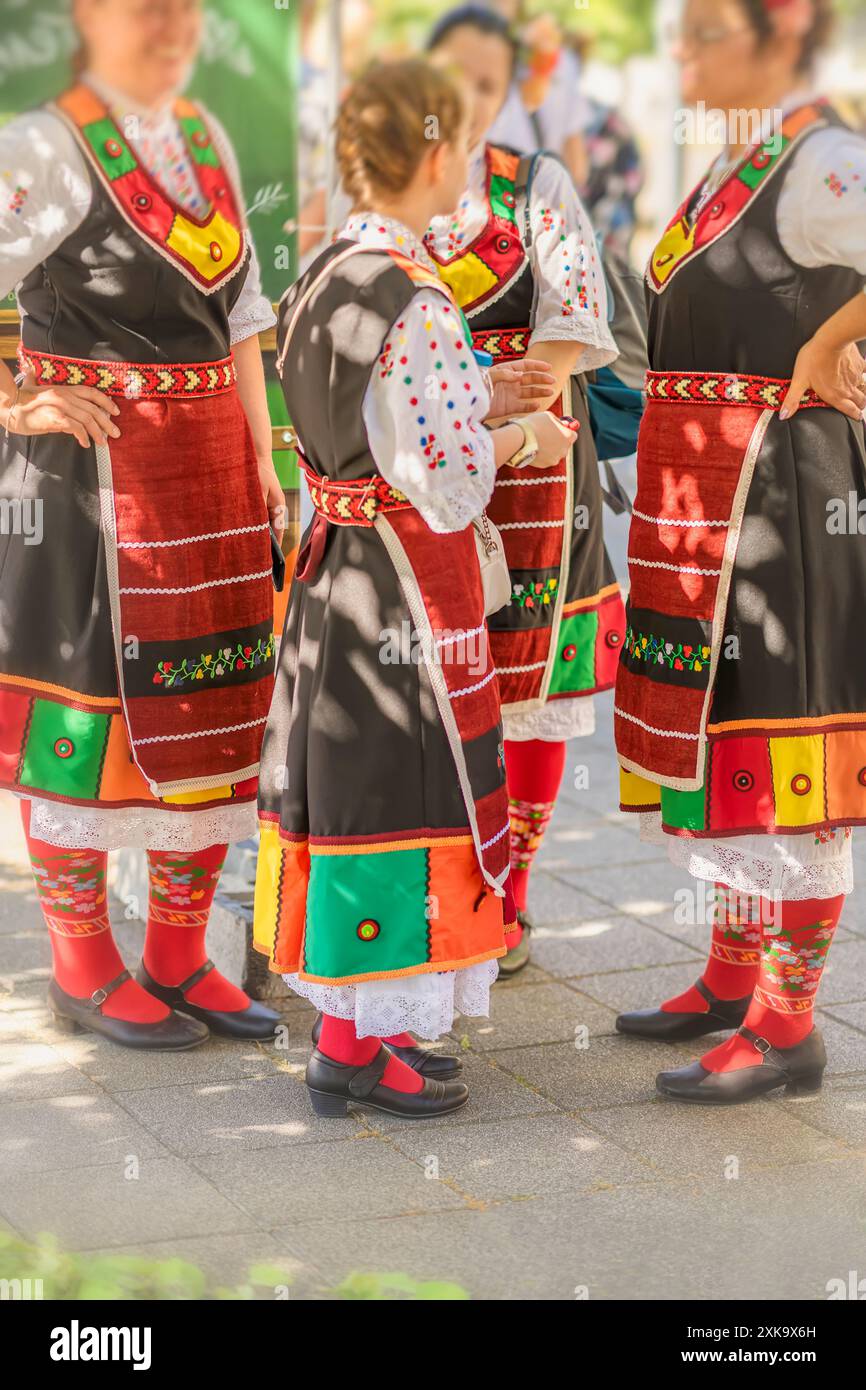 Gruppe von Frauen in traditionellen bulgarischen Volkstrachten mit lebhaften Farben, die an einem Kulturfest teilnehmen Stockfoto