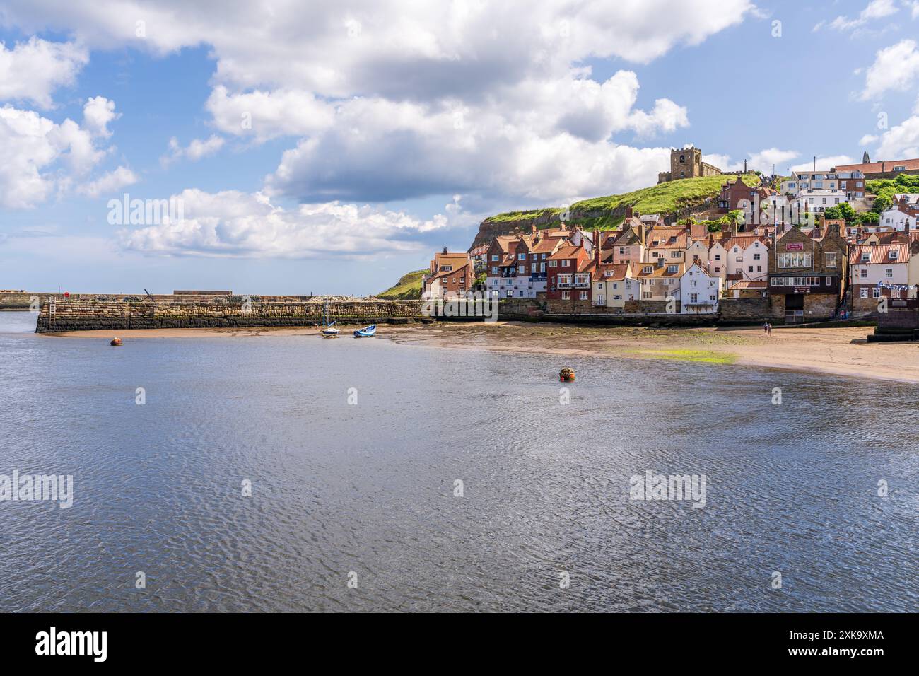 Whitby, North Yorkshire, England, Großbritannien - 21. Juni 2023: Blick auf die Häuser am East Cliff und die Kirche St. Mary Stockfoto