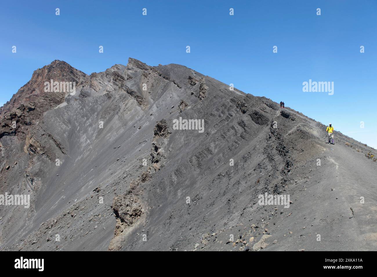 Wanderer wandern auf dem felsigen Kraterkamm des Mount Meru in Afrika. Stockfoto