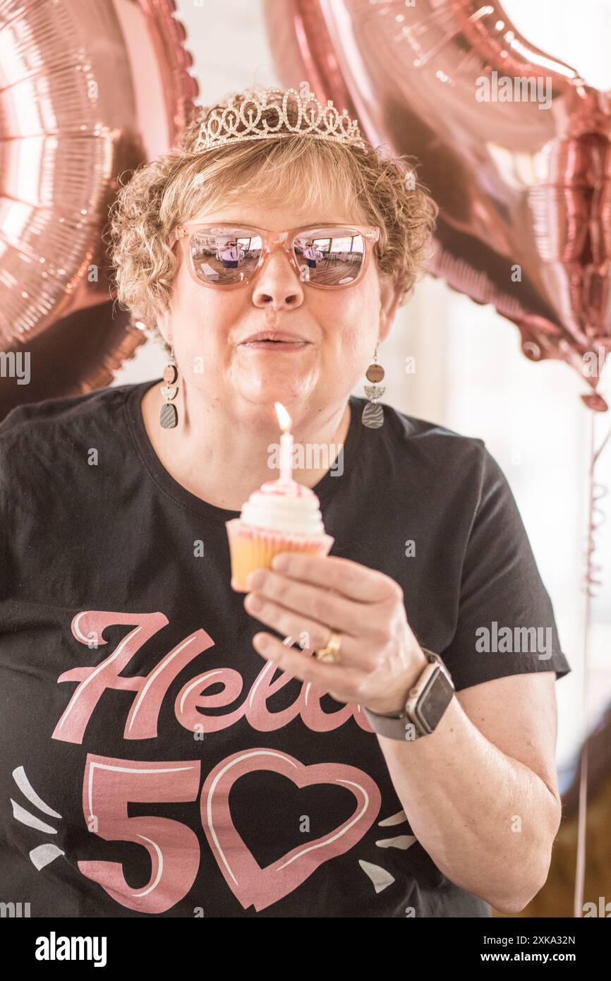 Frau, die ihren 50. Geburtstag feiert und die Kerze ausbläst Stockfoto