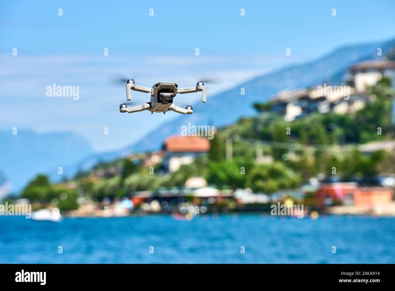 Malcesine, Gardasee, Italien - 20. Juli 2024: Eine DJI Mini 4K Drohne schwebt über dem Wasser im Urlaub am Gardasee. Symbolische Bildgesetze und Regeln für Drohnen mit Kameras im Ausland *** eine DJI Mini 4K Drohne schwebt über dem Wasser im Urlaub am Gardasee. Symbolbild gesetze und Regeln für Drohnen mit Kamera im Ausland Stockfoto