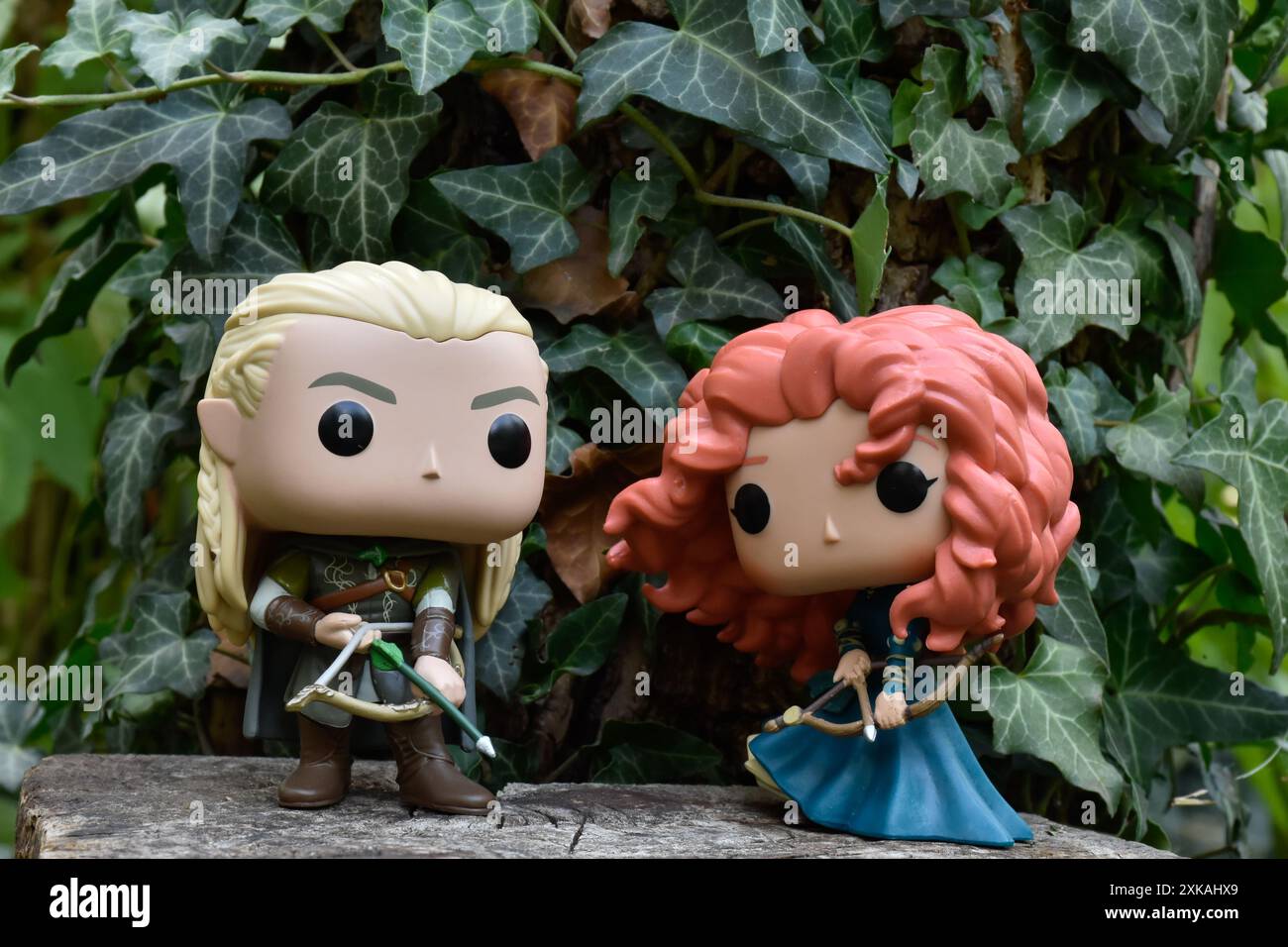 Funko Pop Actionfiguren von Elf Legolas aus dem Film der Herr der Ringe und Prinzessin Merida aus dem Zeichentrickfilm Brave. Bogenschützen im Efeu-grünen Wald. Stockfoto