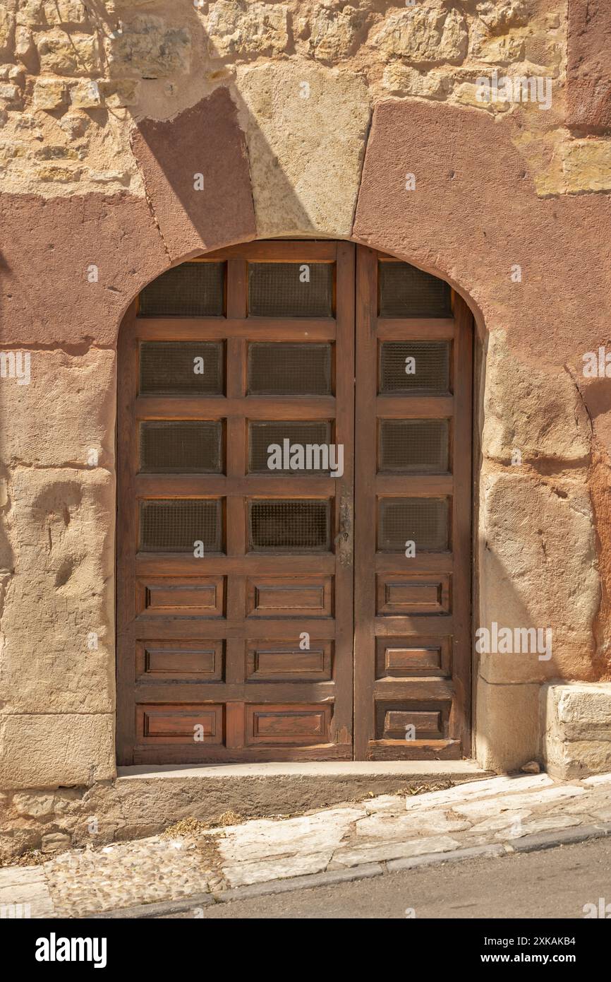 Steinfassaden mit Holztüren verbinden die Stärke und Haltbarkeit von Stein mit der Wärme und dem ästhetischen Charme von Holz Stockfoto
