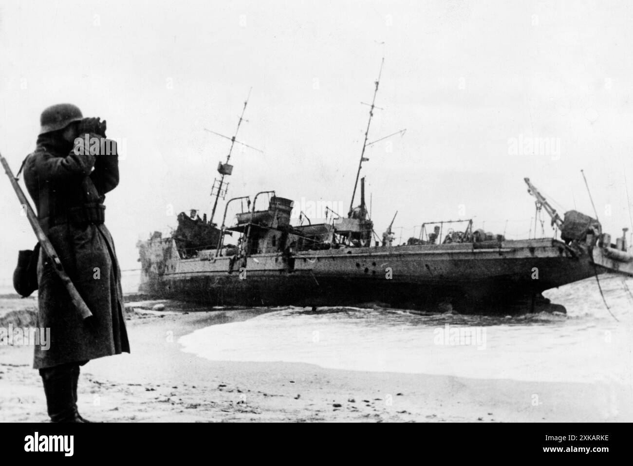 Ein deutscher Soldat im Wachdienst an der Küste der Krim. Im Hintergrund lag ein russisches Schiff, nachdem es beschädigt worden war. Foto: Zündorf [automatisierte Übersetzung] Stockfoto