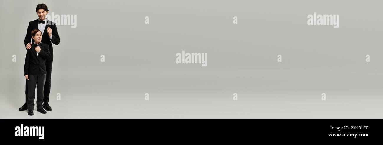 Ein Vater hilft seinem Sohn, seine Fliege für einen besonderen Anlass anzupassen. Stockfoto