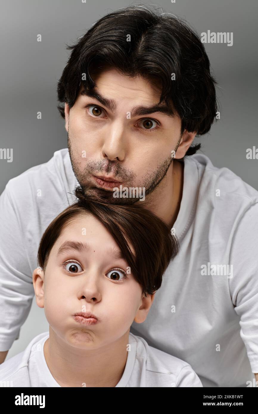 Ein Mann und ein kleiner Junge machen lustige Gesichter zusammen. Stockfoto