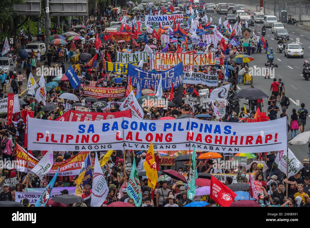Quezon City, Philippinen. Juli 2024. Demonstranten marschieren mit Bannern, die ihre Meinung auf der Commonwealth Avenue während der Demonstration zum Ausdruck bringen. Aktivisten und Menschenrechtsaktivisten versammeln sich auf den Straßen, um ihre Ansichten und ihre Missbilligung über die dritte Station der Nation von Präsident Marcos Jr. zu übermitteln. Der Präsident plante, eine Reihe von Themen zu erörtern, darunter Inflation, Arbeitslosigkeit und höchstwahrscheinlich die gegenwärtige Krise in der Westphilippinischen See. Quelle: SOPA Images Limited/Alamy Live News Stockfoto