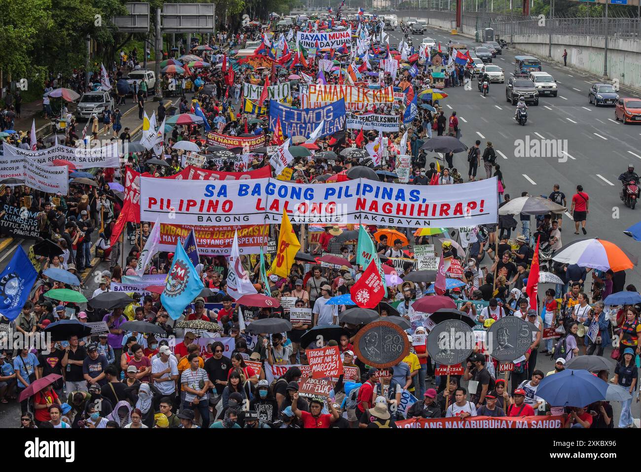 Quezon City, Philippinen. Juli 2024. Demonstranten marschieren mit Bannern, die ihre Meinung auf der Commonwealth Avenue während der Demonstration zum Ausdruck bringen. Aktivisten und Menschenrechtsaktivisten versammeln sich auf den Straßen, um ihre Ansichten und ihre Missbilligung über die dritte Station der Nation von Präsident Marcos Jr. zu übermitteln. Der Präsident plante, eine Reihe von Themen zu erörtern, darunter Inflation, Arbeitslosigkeit und höchstwahrscheinlich die gegenwärtige Krise in der Westphilippinischen See. Quelle: SOPA Images Limited/Alamy Live News Stockfoto