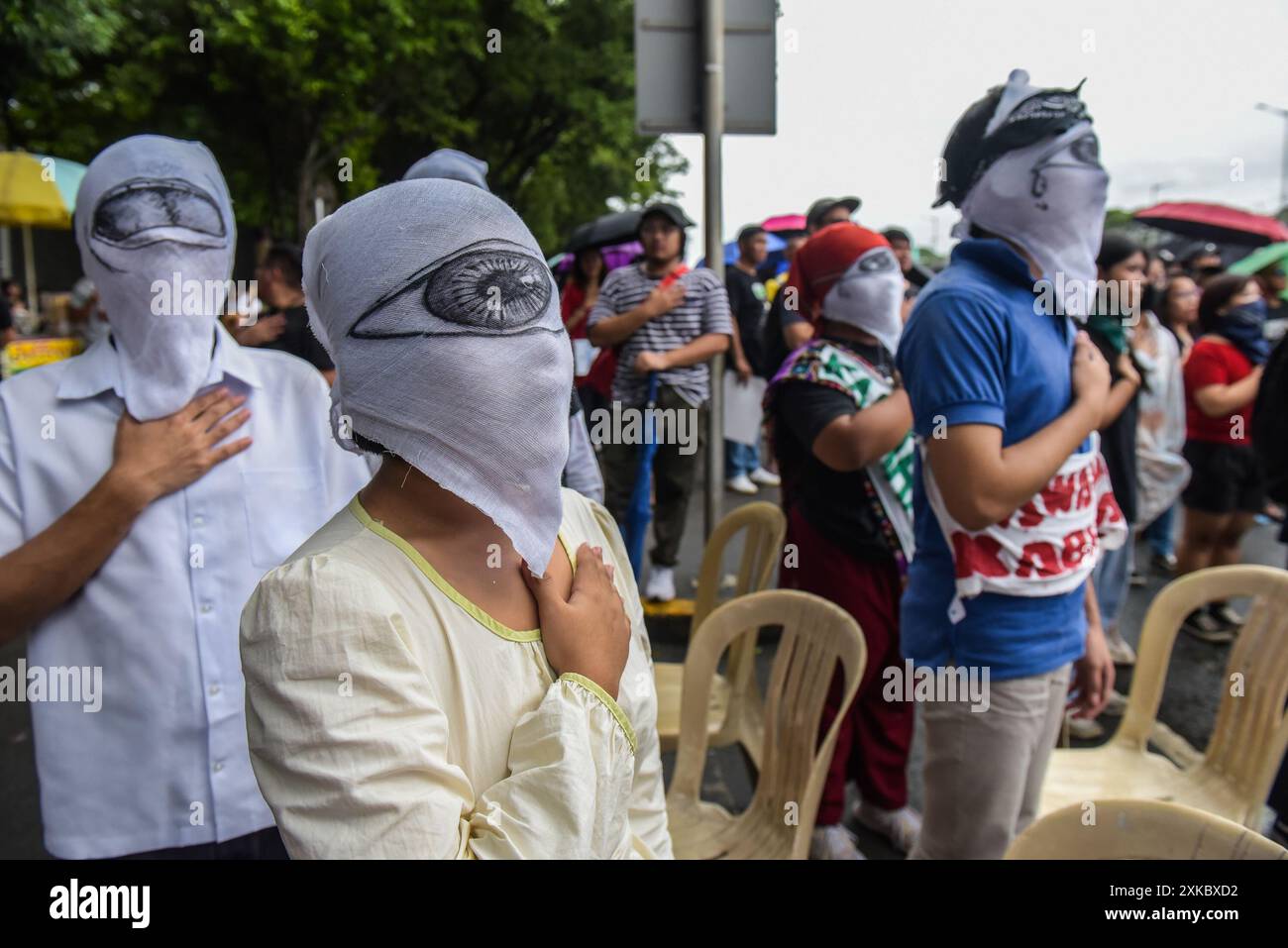 Quezon City, Philippinen. Juli 2024. Maskierte Demonstranten singen während der Demonstration die philippinische Nationalhymne auf der Commonwealth Avenue. Aktivisten und Menschenrechtsaktivisten versammeln sich auf den Straßen, um ihre Ansichten und ihre Missbilligung über die dritte Station der Nation von Präsident Marcos Jr. zu übermitteln. Der Präsident plante, eine Reihe von Themen zu erörtern, darunter Inflation, Arbeitslosigkeit und höchstwahrscheinlich die gegenwärtige Krise in der Westphilippinischen See. Quelle: SOPA Images Limited/Alamy Live News Stockfoto