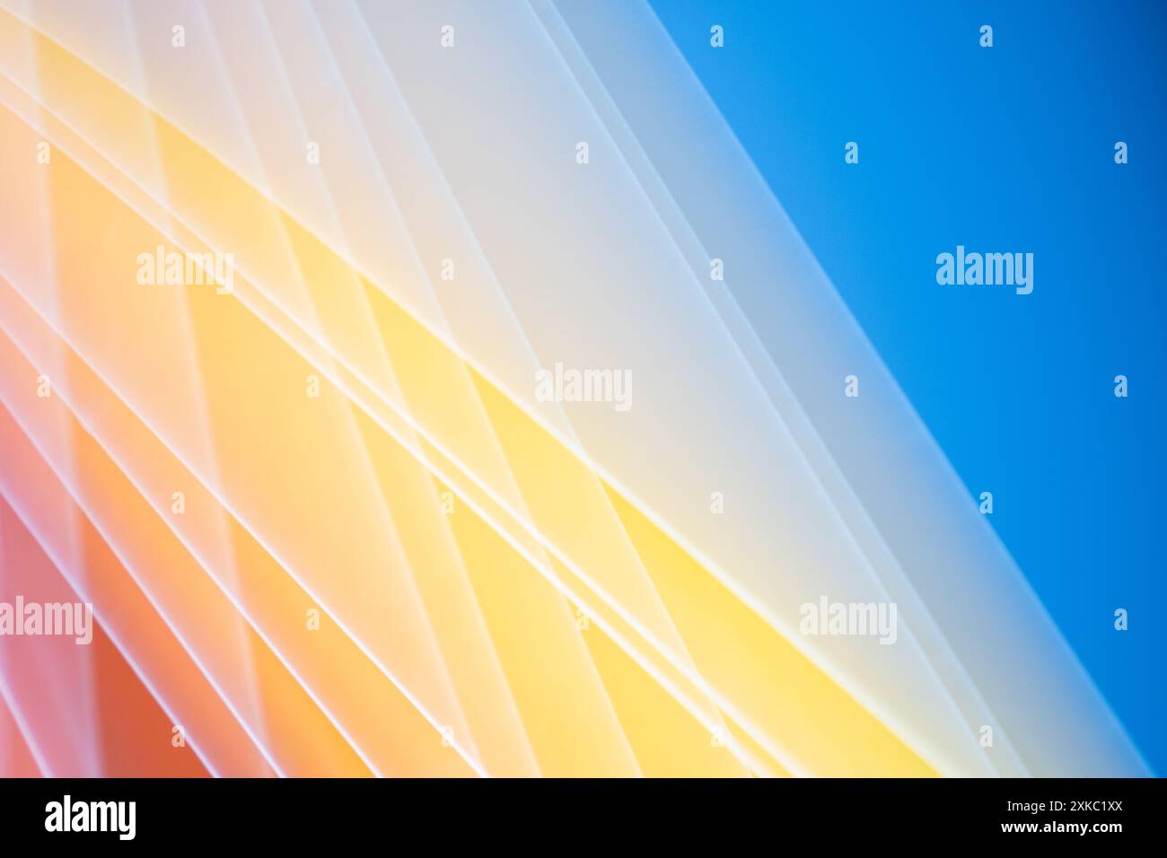 Ein lebendiger Hintergrund aus diagonalen gelben Streifen vor einem hellblauen Hintergrund Stockfoto